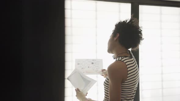 Businesswoman talking on cell phone while reviewing documents alt