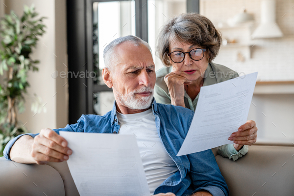 Senior old elderly spouses grandparents reading documents, having issue problem debt with money
