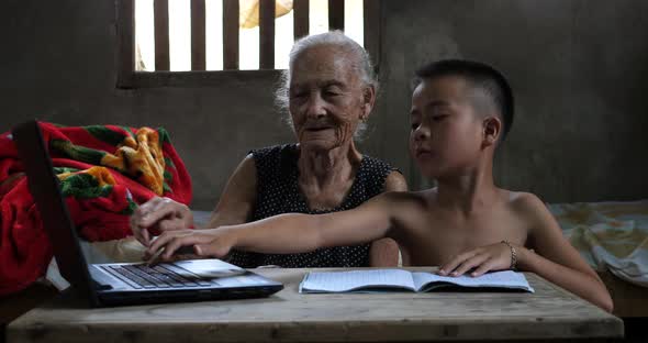 Boy Teaching His Grandmother Use Computer alt