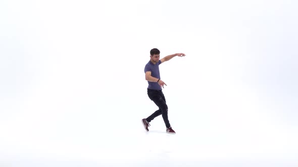 Man Is Dancing Breakdance on the White Background in Simple Grey T-shirt and Grey Jeans. Slow Motion alt
