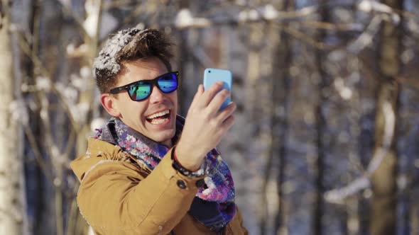 Happy Guy Throwing Snow Up in Front of Camera alt