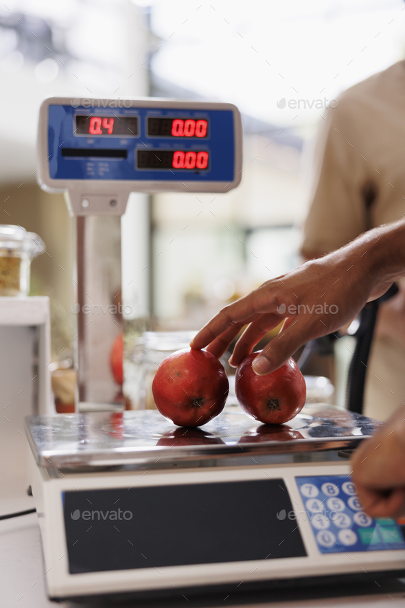 Cashier using weighing machine in store