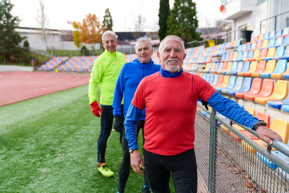 Joyful Senior Runners Bonding on Athletic Track