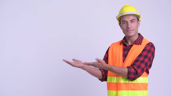 Young Happy Hispanic Man Construction Worker Showing Something alt