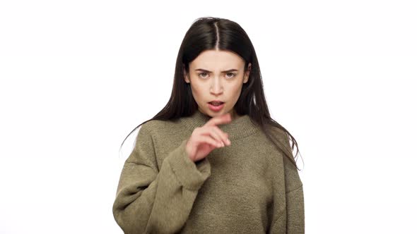 Portrait of Serious Brunette Woman with Long Hair Holding Index Finger on Lips and Strictly Asking alt