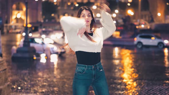 night dance - woman dancing on the street at night smiling at the camera alt