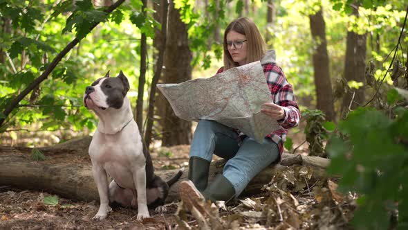 Portrait of Thoughtful Focused Young Woman Choosing Direction in Forest Examining Paper Map Looking alt