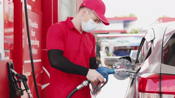 Pumping gas at gas station. Close up of a hand holding fuel alt