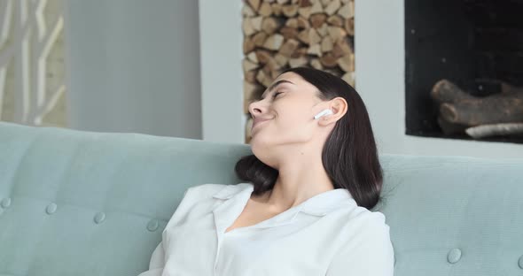 A Relaxed Young Smiling Woman Wearing Wireless Headphones alt