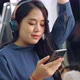 Young Woman Using Mobile Phone on Public Train