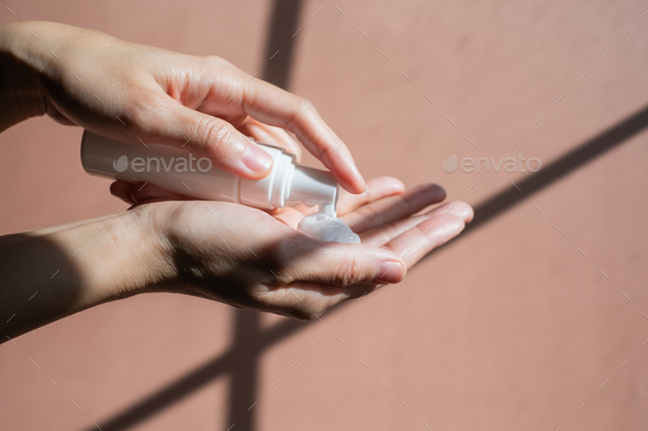 Woman is using skincare facial foam cleanser and pump it on her hand.