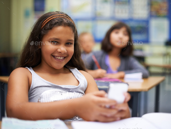 Sending a text in class Stock Photo by YuriArcursPeopleimages | PhotoDune