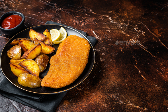 Roast pork schnitzel with fried potato, cooked meat steak. Dark ...