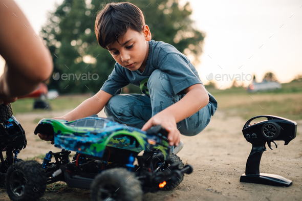 Boy putting back the shell on a remote controlled race car toy Stock ...
