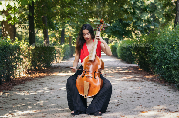Woman playing the cello in a park.