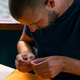 a young man strings a fishing line or a fly on hook for fishing feeder free  style method Stock Photo by guyswhoshoot