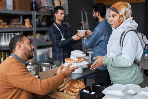 Middle Eastern Woman Receiving Food at Refugee Help Center