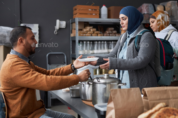 Middle Eastern Woman Receiving Meal in Refugee Help Center