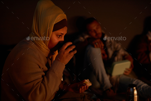 Middle Eastern woman drinking tea in bomb shelter