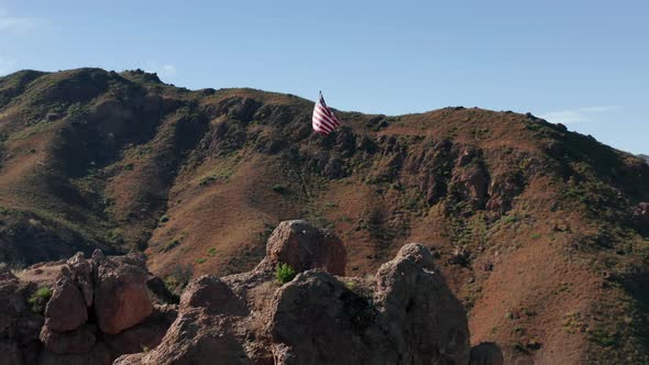 Drone Flying Around the Striped Flag Set Up in the Rocky Mountain, Malibu USA alt