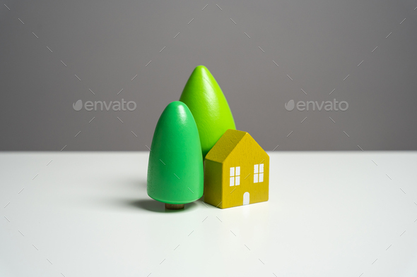 House with trees, figurine. Environmental friendliness and autonomy of housing.