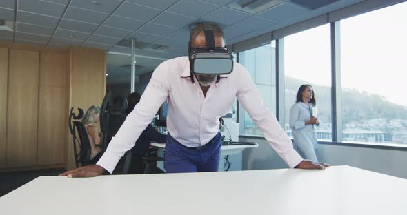 African American businessman wearing VR headset in modern office alt