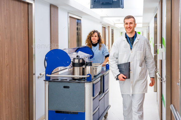 Doctor next to a nurse with a trolley with coffee