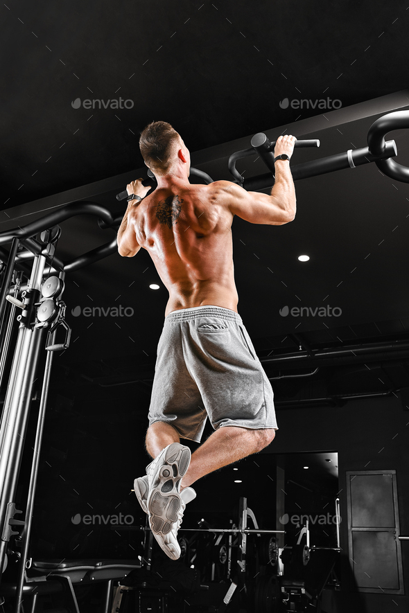 Bodybuilder does pull-ups. Muscular man in the gym. Preparation for ...