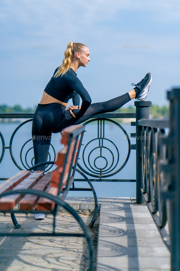 Young beautiful woman running in park in the morning. Sporty girl jogging  along embankment Stock Photo