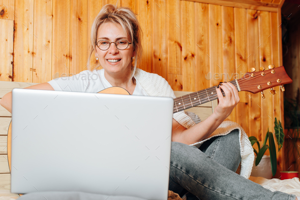 Learn music, online lesson, musical hobbies and leisure activities. Happy middle aged caucasian woma