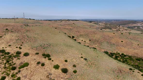 Aerial View of Electricity Transmission Pylon in Dry Valley Landscape alt