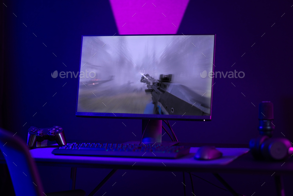 Colorful e-sport gaming and streaming studio with first-person shooter online video game on computer