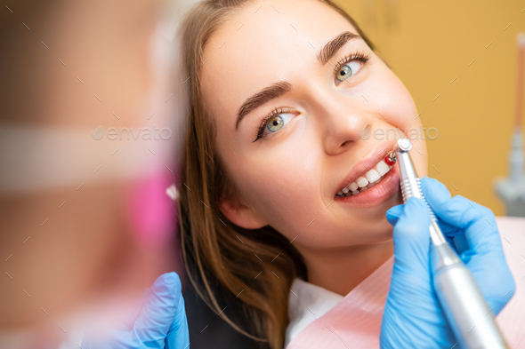 Dentist performing teeth grinding procedures in clinic
