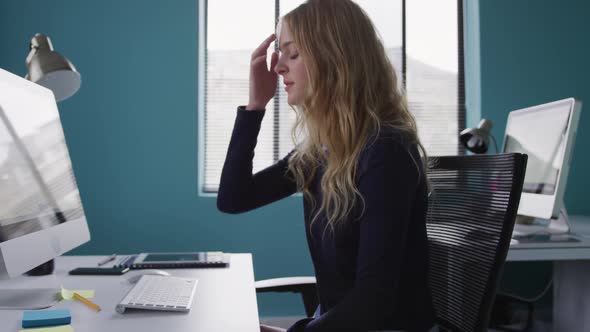 Caucasian woman tired at the office alt