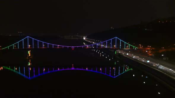 City Traffic at Night on the Highway Near the Pedestrian Park Bridge Aerial View alt