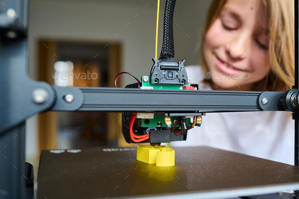 A 10-year-old boy watches the 3D printing process with rapt attention
