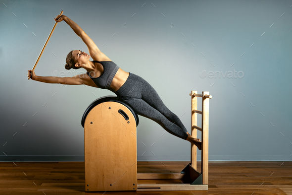 Pilates trainer exercises on a pilates barrel. Body training, perfect body  shape and posture Stock Photo by Gerain0812