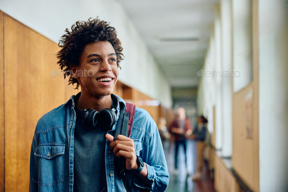 Happy African American student at high school looking away.
