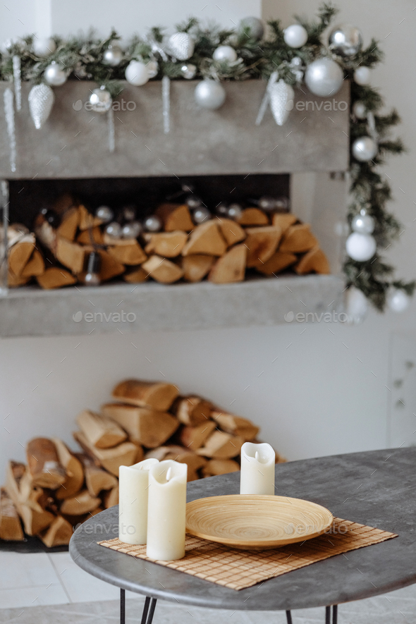 Cozy indoor setting, candles, gifts, firewood.
