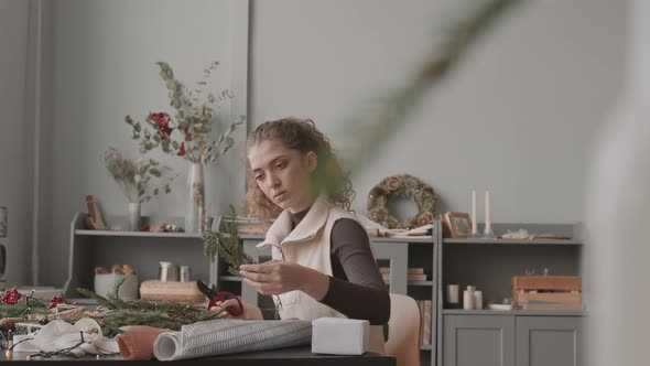 Woman Cutting Christmas Tree Branches alt