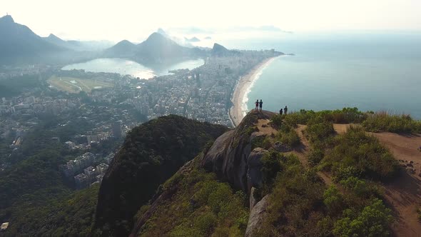 Overhead Aerial Drone Shot Over a Mountain Top Revealing Two Young Adults Admiring the View alt
