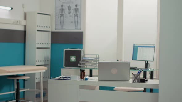Empty Office Desk with Laptop and Medical Instruments alt