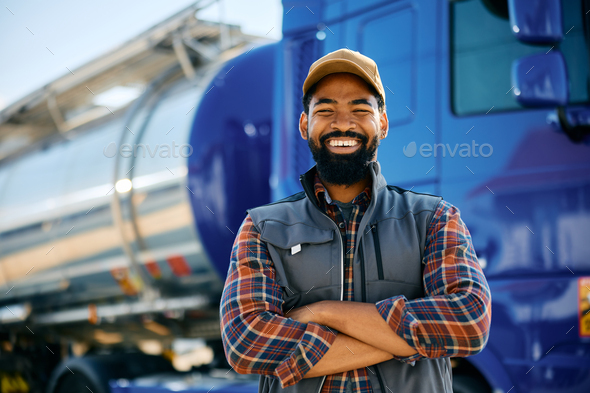 Happy black truck driver with arms crossed looking at camera.