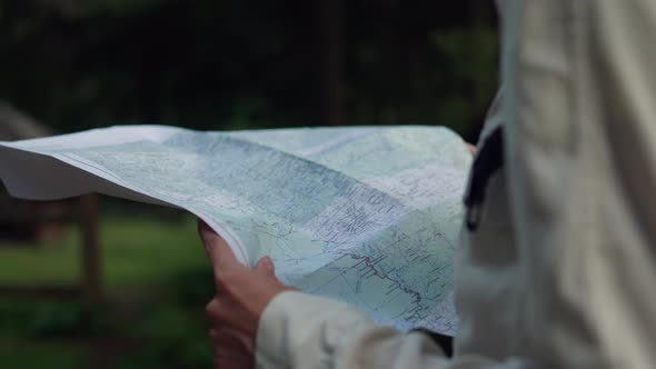 Tourist Traveler Arrived At The Destination. A Woman Holds Map In Her Hands And Goes Along The Route alt