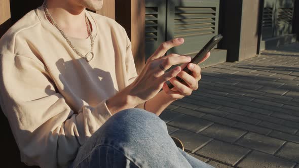 Cropped Guy Using Smartphone Outdoors alt