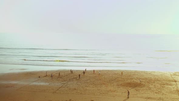 Young Men Playing Football on Beach at Sunset Silhouette of People on the Beach of Atlantic Ocean alt