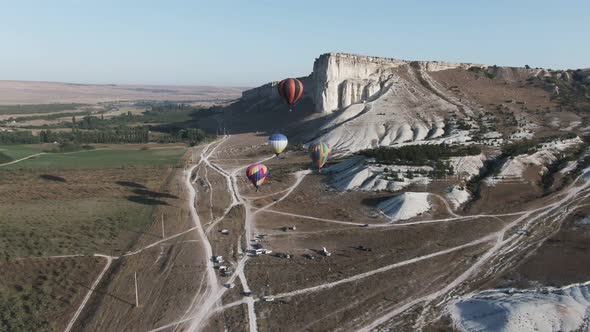 Four Balloons Take Off in the Sky at Dawn Against a White Rock Crimea White Rock August 2019 alt