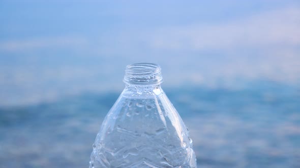 Drink Water Background. Bottle with Water Splashes and Seawater on Background. Social Art for alt