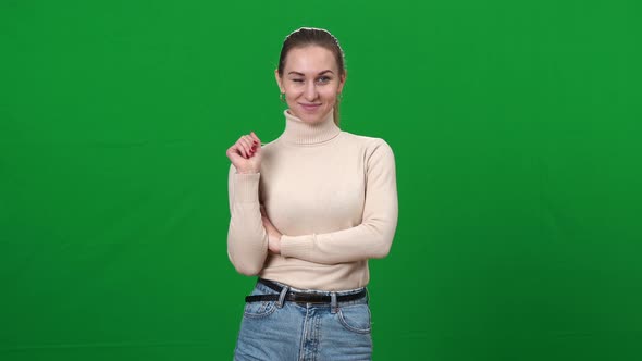 Beautiful Confident Young Woman Waving at Camera Winking on Green Screen alt