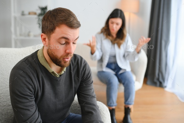 Couple Arguing Wife Shouting To Her Desperate Husband Sitting On A Couch In The Living Room At 5702